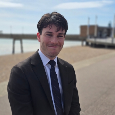 a picture of Findlay Fletcher sat on Deal Seafront with the pier in the background.